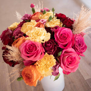 Cheers flower bouquet with roses, ranunculus, carnation, solomio, and pampas in a vase