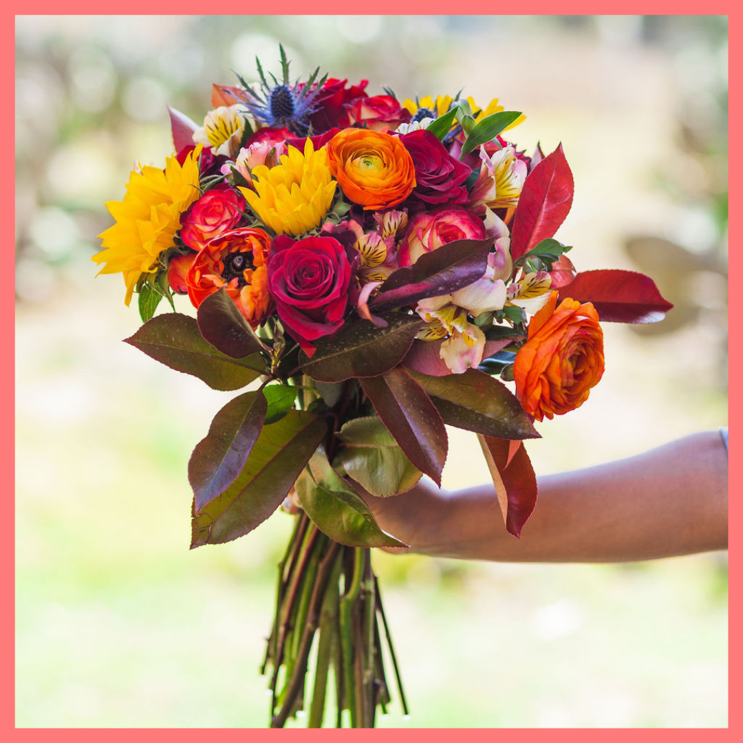 The Pumpkin Nice flower bouquet includes mixed stems of sunflowers, roses, ranunculus, alstroemeria, photinea, and eryngium. Please note that as flowers are a live product, colors and varieties may slightly vary from the photos shown to provide you with the freshest and most beautiful bouquet.