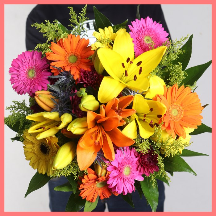 The Autumn Vibes bouquet includes mixed stems of lilies, gerbera daisies, CDN pompoms, eryngium, cocculus, aster, and pittosporum!