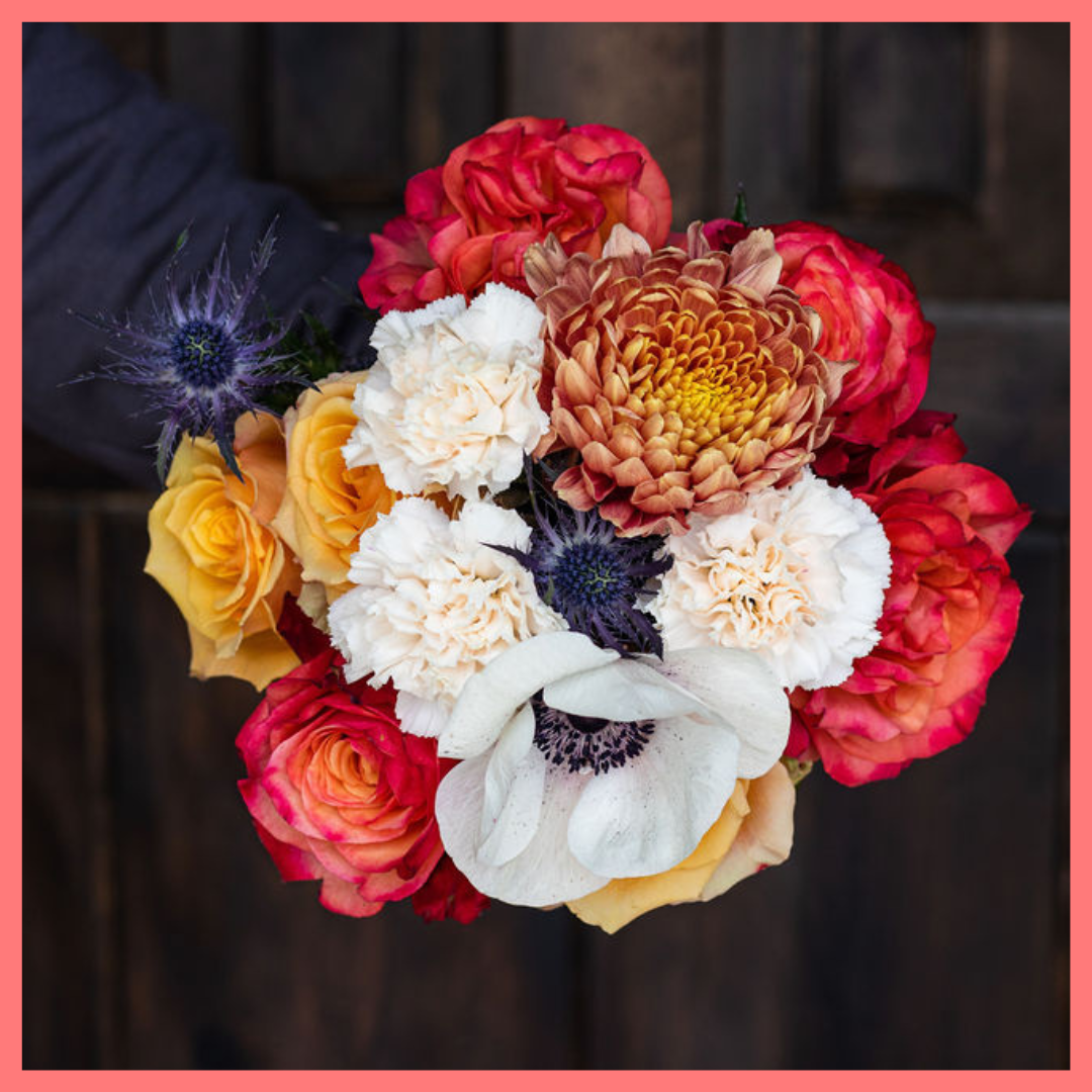 The Harvest Festival bouquet includes mixed stems of roses, anemone, delphinium, eryngium, chrysanthemums, bunny tail, and carnation!