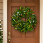 Classic Evergreen fresh wreath of mixed greenery and magnolia leaves hanging on a wood front door in winter