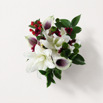 White and plum calla lilies with red berries and glossy greenery, seen from above