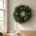 Home for the Holidays wreath styled on a sunlit bedroom wall above a wood headboard
