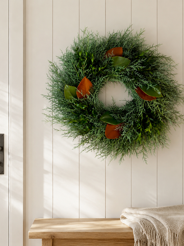 Holiday Cheer Wreath, an 18-inch fresh wreath, on a white shiplap wall above a wood bench