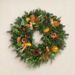 Spice Up the Holidays fresh wreath of fir, boxwood, magnolia, dried orange slices, cinnamon-stick bundles, and pinecones
