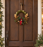 The Bronze Willow Wreath hanging on a dark wood front door
