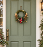 The Bronze Willow Wreath hanging on a sage green front door