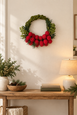 The Cranberry Willow Wreath styled on a wall above a console table