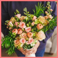Order The Susie flower bouquet from our Mother's Day Collection.The Susie bouquet includes mixed stems of roses, coral ranunculus, stock, solomio, spray roses, and podocarpus greens. The flowers will be shipped directly from the farm to you!