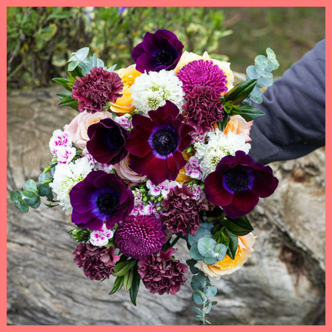 The Farm Days bouquet includes mixed stems of roses, carnation, anemone, scabiosa, hebes, eucalyptus, and chrysanthemums!