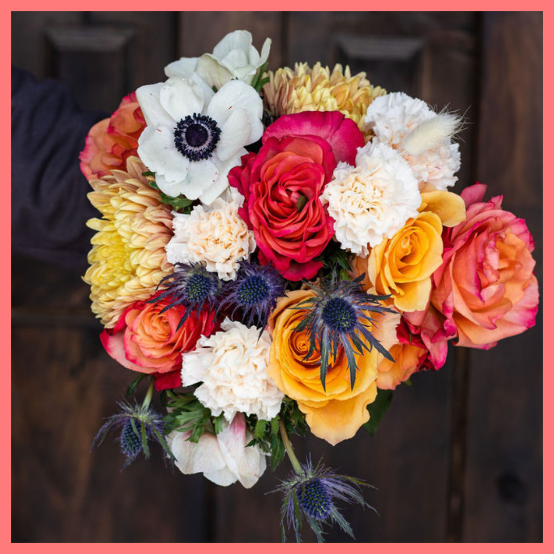 The Harvest Festival bouquet includes mixed stems of roses, anemone, delphinium, eryngium, chrysanthemums, bunny tail, and carnation!