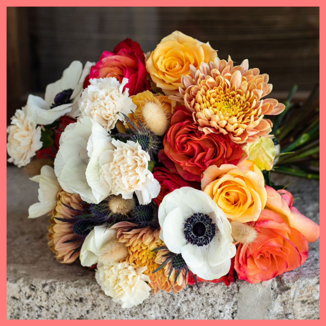 The Harvest Festival bouquet includes mixed stems of roses, anemone, delphinium, eryngium, chrysanthemums, bunny tail, and carnation!
