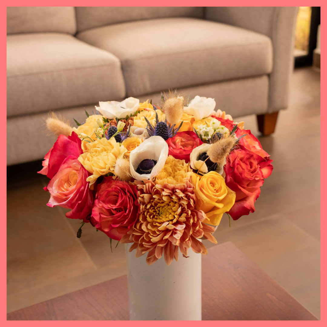The Harvest Festival bouquet includes mixed stems of roses, anemone, delphinium, eryngium, chrysanthemums, bunny tail, and carnation!
