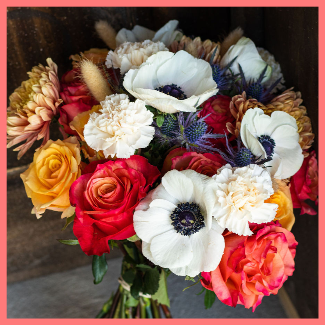 The Harvest Festival bouquet includes mixed stems of roses, anemone, delphinium, eryngium, chrysanthemums, bunny tail, and carnation!
