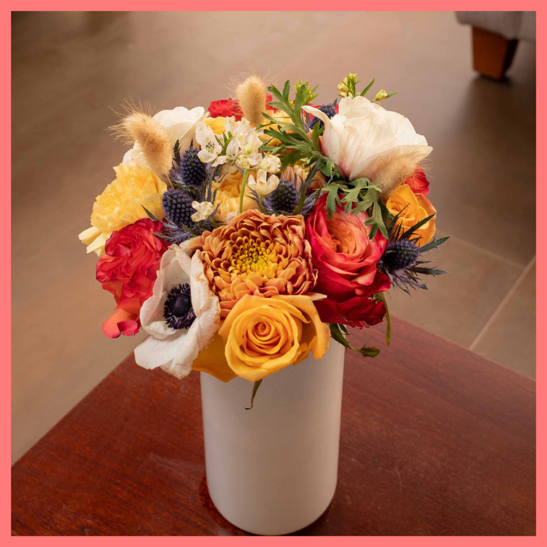 The Harvest Festival bouquet includes mixed stems of roses, anemone, delphinium, eryngium, chrysanthemums, bunny tail, and carnation!