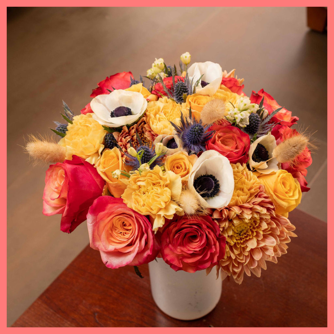 The Harvest Festival bouquet includes mixed stems of roses, anemone, delphinium, eryngium, chrysanthemums, bunny tail, and carnation!
