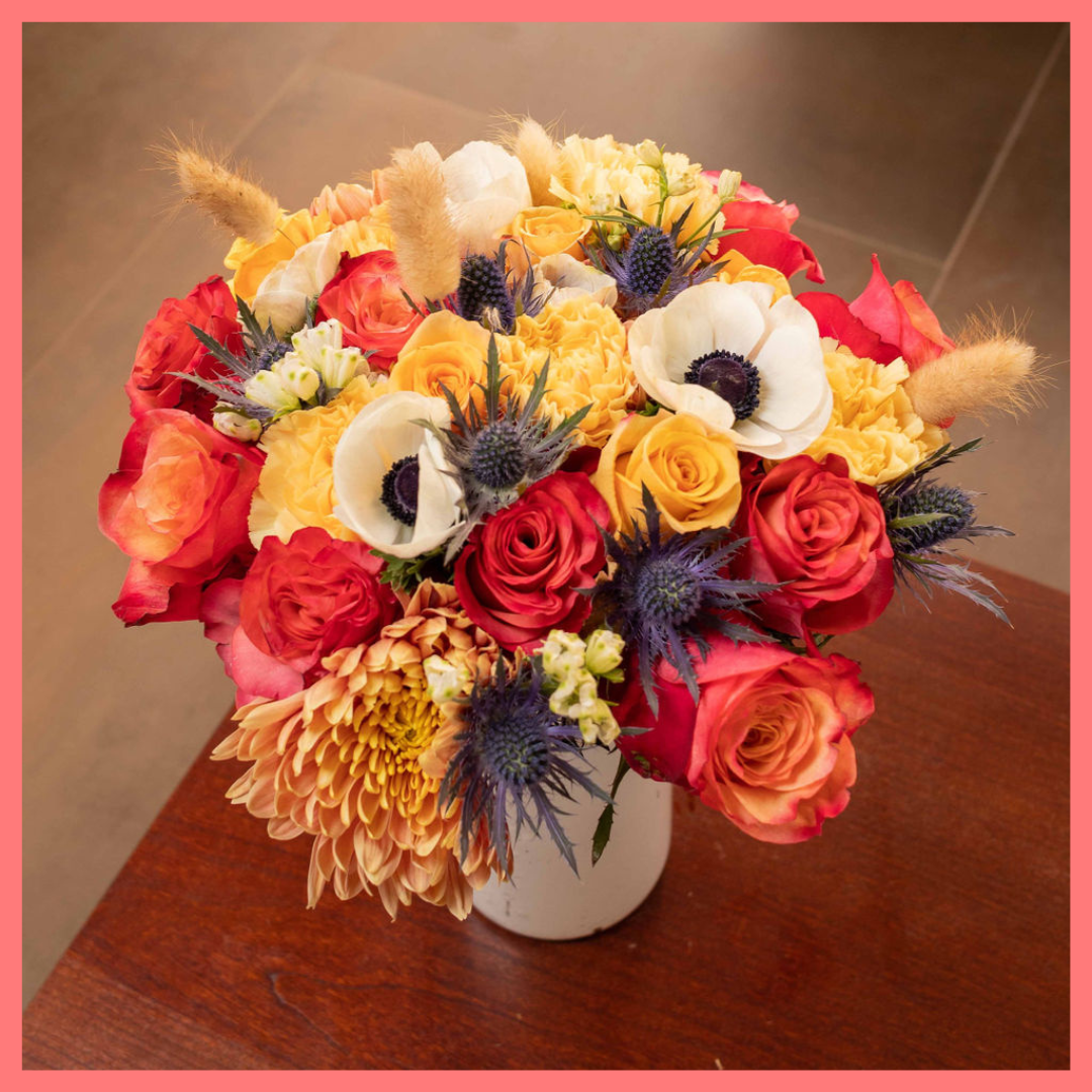 The Harvest Festival bouquet includes mixed stems of roses, anemone, delphinium, eryngium, chrysanthemums, bunny tail, and carnation!