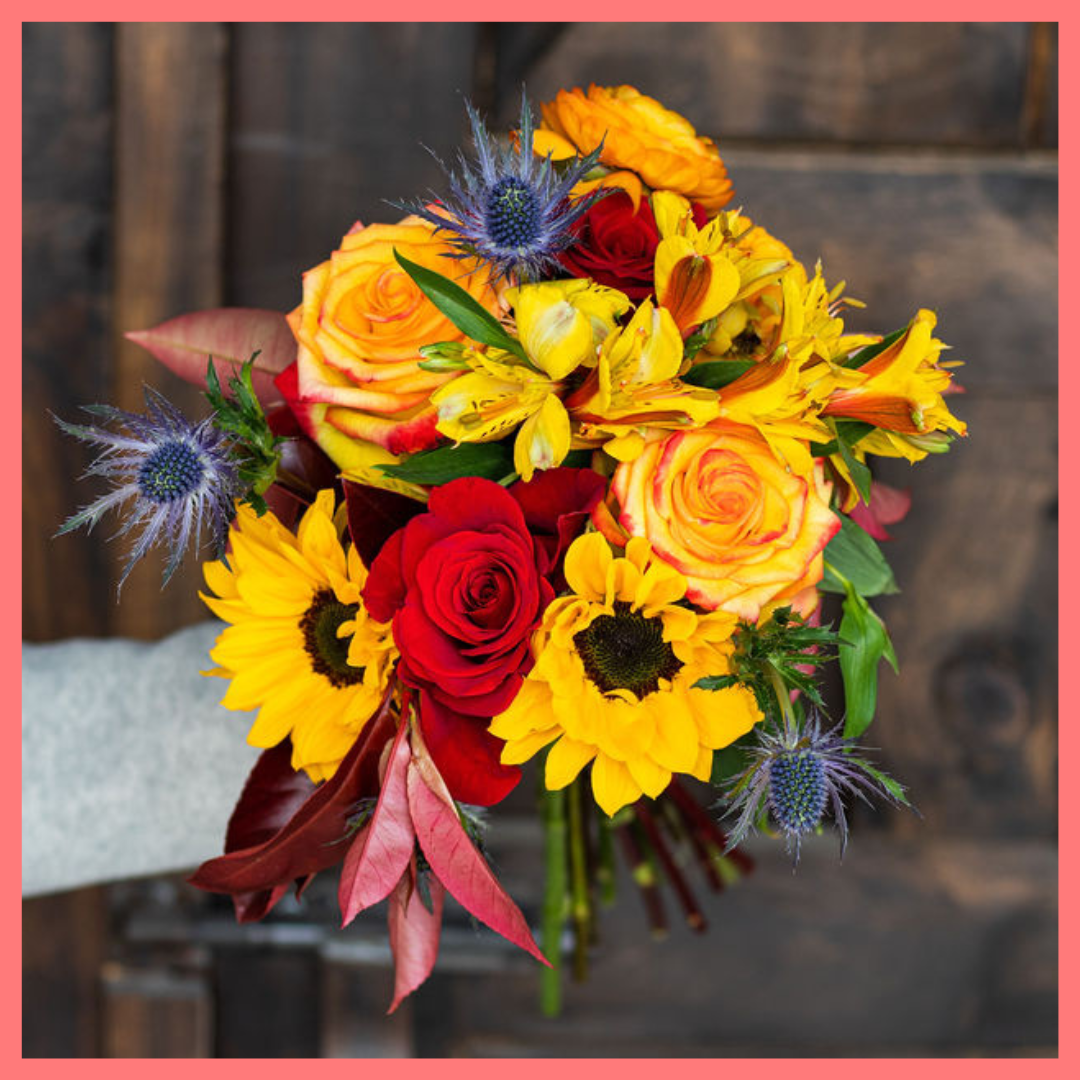 The Pumpkin Nice bouquet includes mixed stems of sunflowers, ranunculus, roses, alstroemeria, photinea, and eryngium. Please note that as flowers are a live product, colors and varieties may slightly vary from the photos shown to provide you with the freshest and most beautiful bouquet.