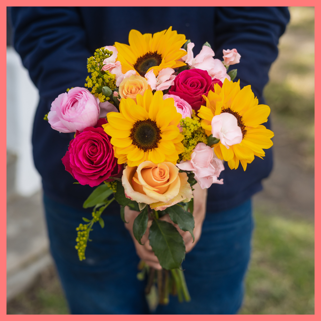 Order the Here Comes The Sun(flower) flower bouquet! The Here Comes The Sun(flower) bouquet includes mixed stems of sunflowers, ranunculus, roses, solomio, and solidago.The flowers will be shipped directly from the farm to you!