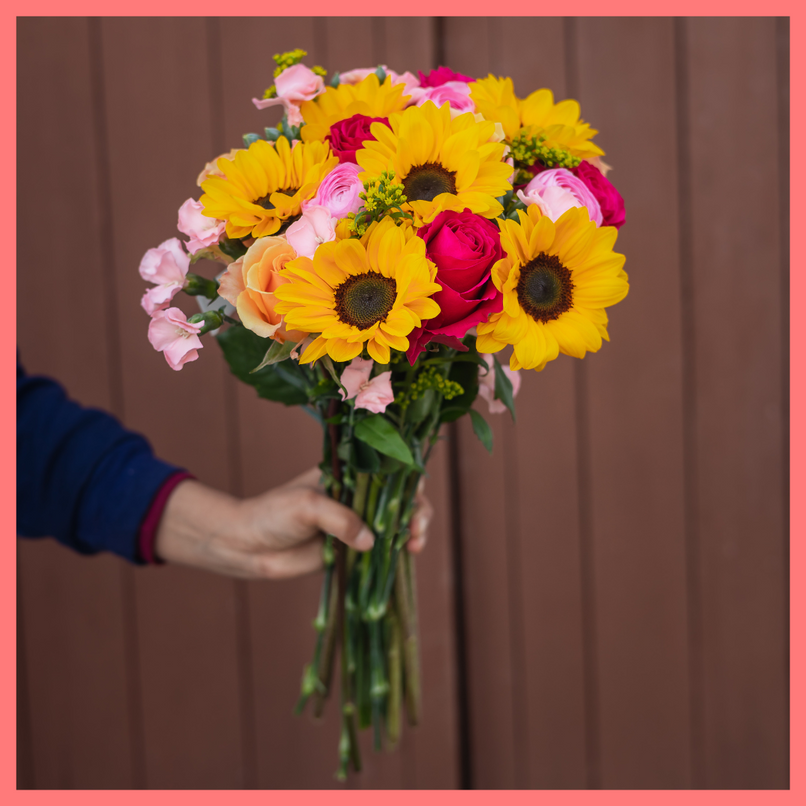 Order the Here Comes The Sun(flower) flower bouquet! The Here Comes The Sun(flower) bouquet includes mixed stems of sunflowers, ranunculus, roses, solomio, and solidago.The flowers will be shipped directly from the farm to you!