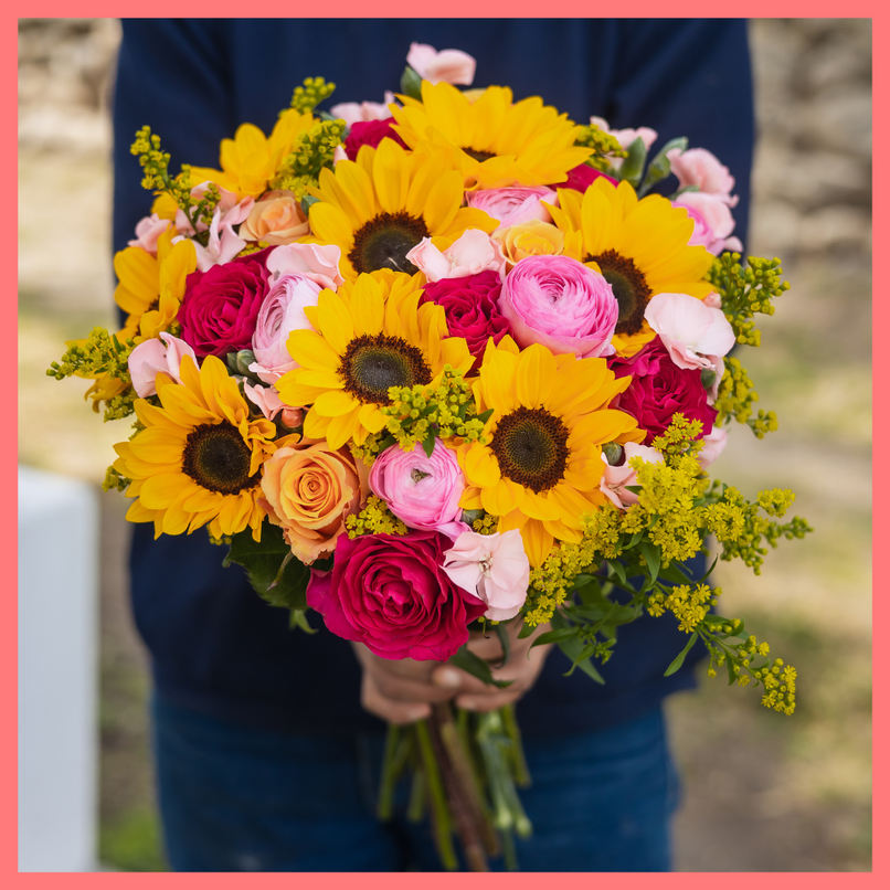Order the Here Comes The Sun(flower) flower bouquet! The Here Comes The Sun(flower) bouquet includes mixed stems of sunflowers, ranunculus, roses, solomio, and solidago.The flowers will be shipped directly from the farm to you!